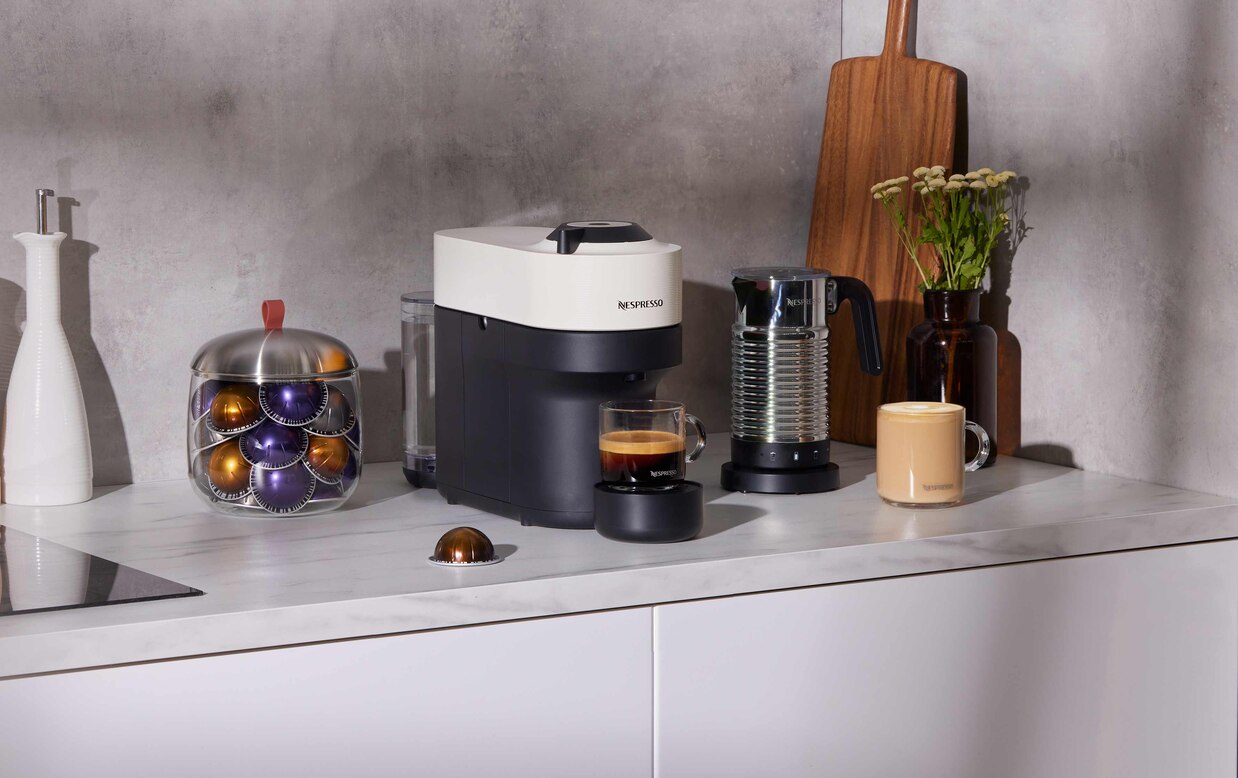 https://www.nespresso.com/ecom/medias/sys_master/public/26791274709022/Vertuo-Pop-CoconutWhite-Aeroccino4-Lifestyle-Main-Media-6272x2432.jpg?impolicy=productPdpSafeZone&imwidth=1238