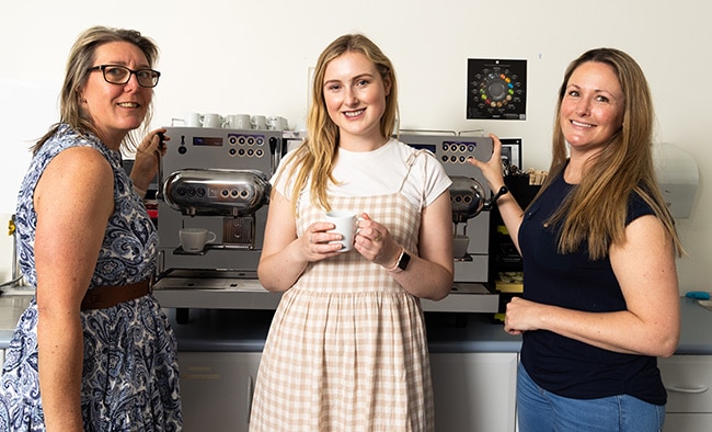 Three women in front of Nespresso Professional coffee machine