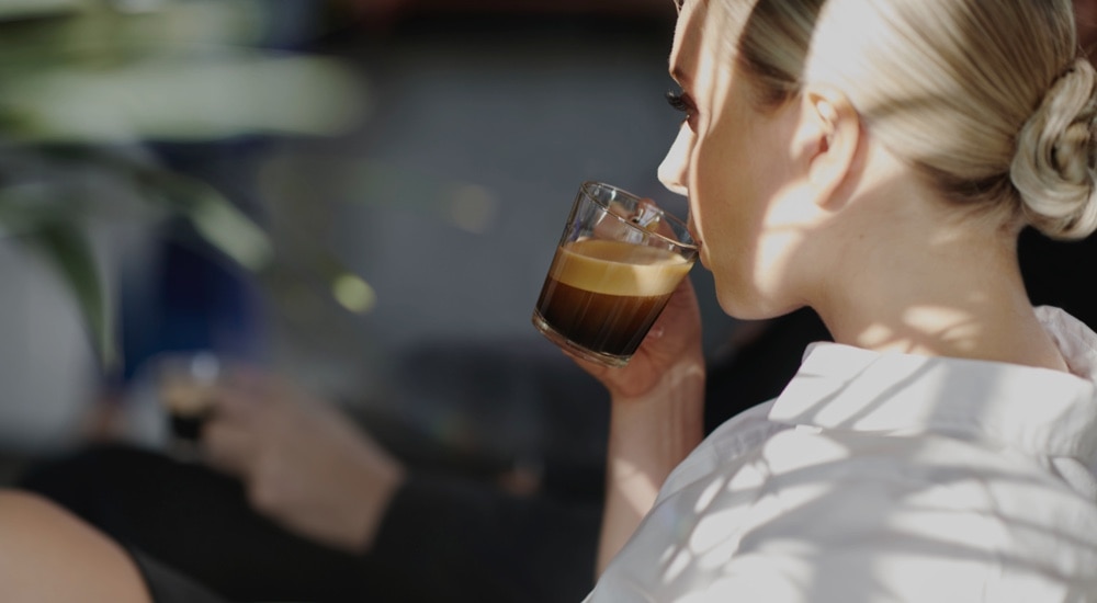 Frau trinkt Kaffee während einem Geschäftsgespräch